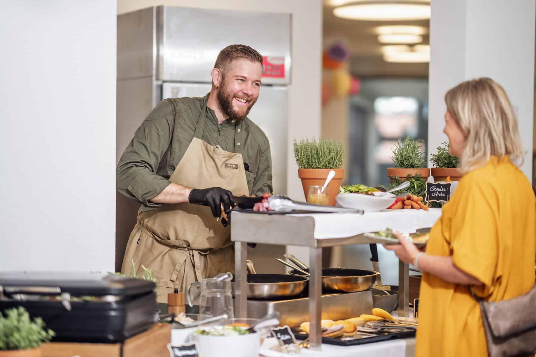 Tobias Jäkel serviert einem Gast am Sonntagsbrunch-Buffet im Glättli