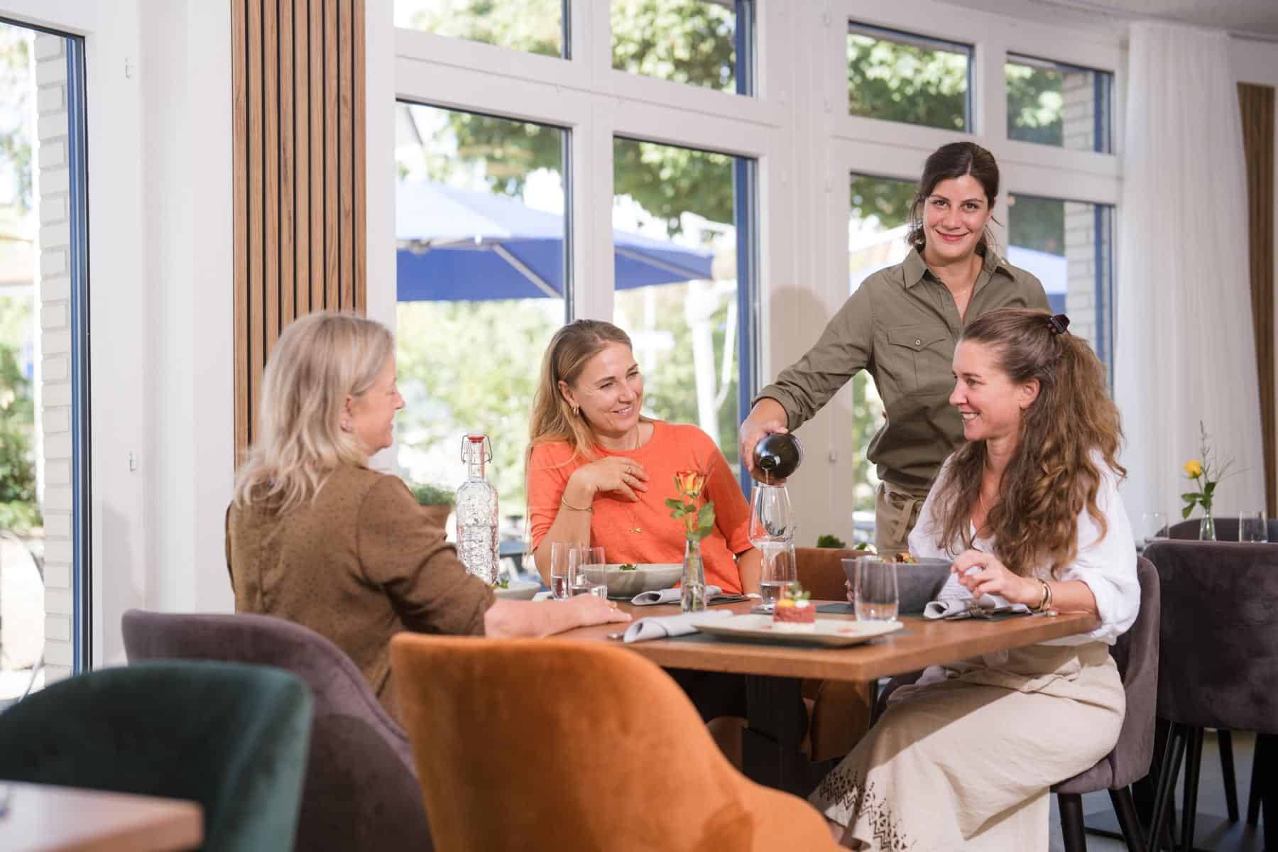 Mitarbeiterin des Glättli schenkt Gästen am Tisch ein